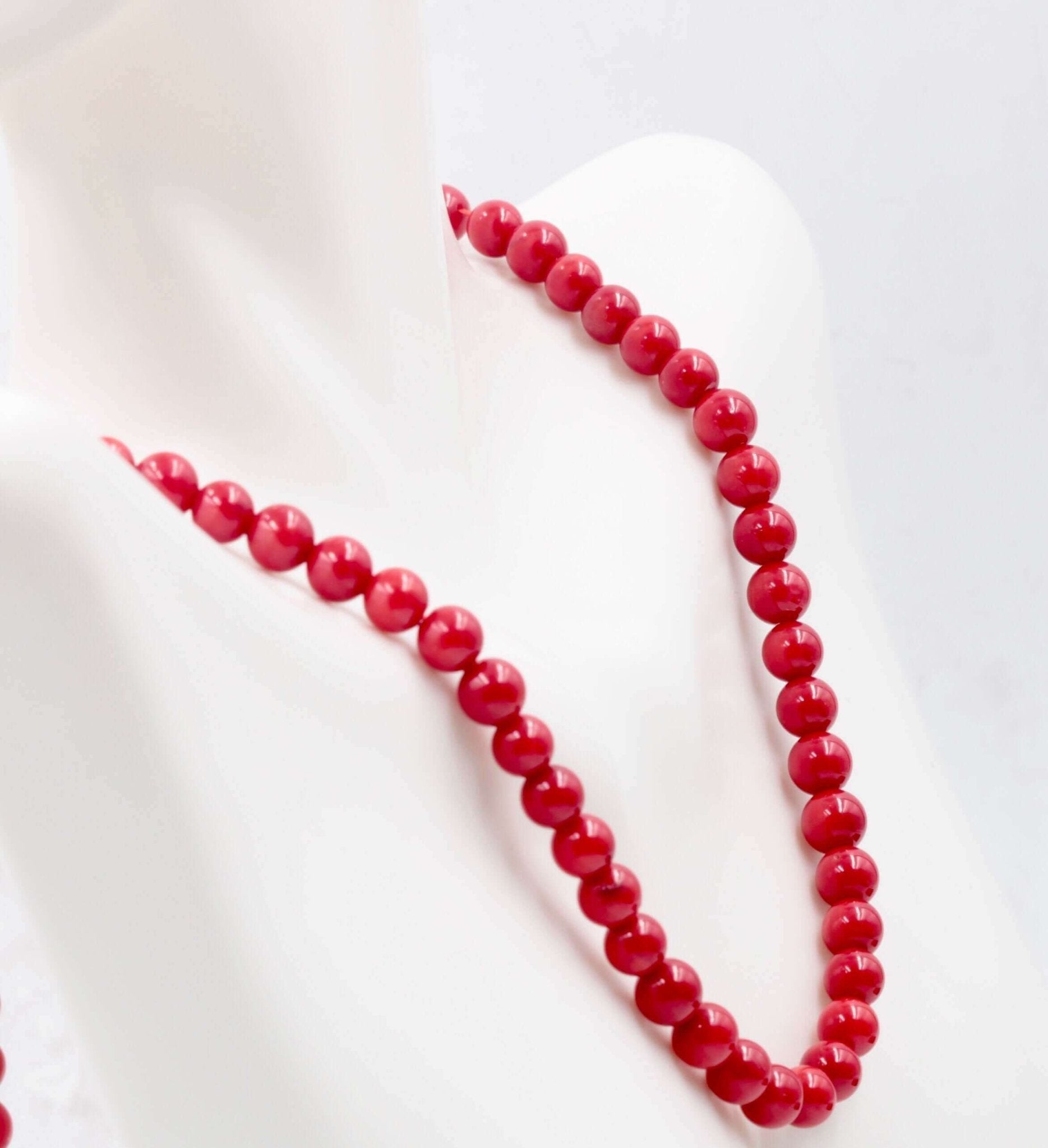 Natural Coral necklace showcasing vibrant red beads symbolizing luck and fortune, displayed elegantly on a mannequin.