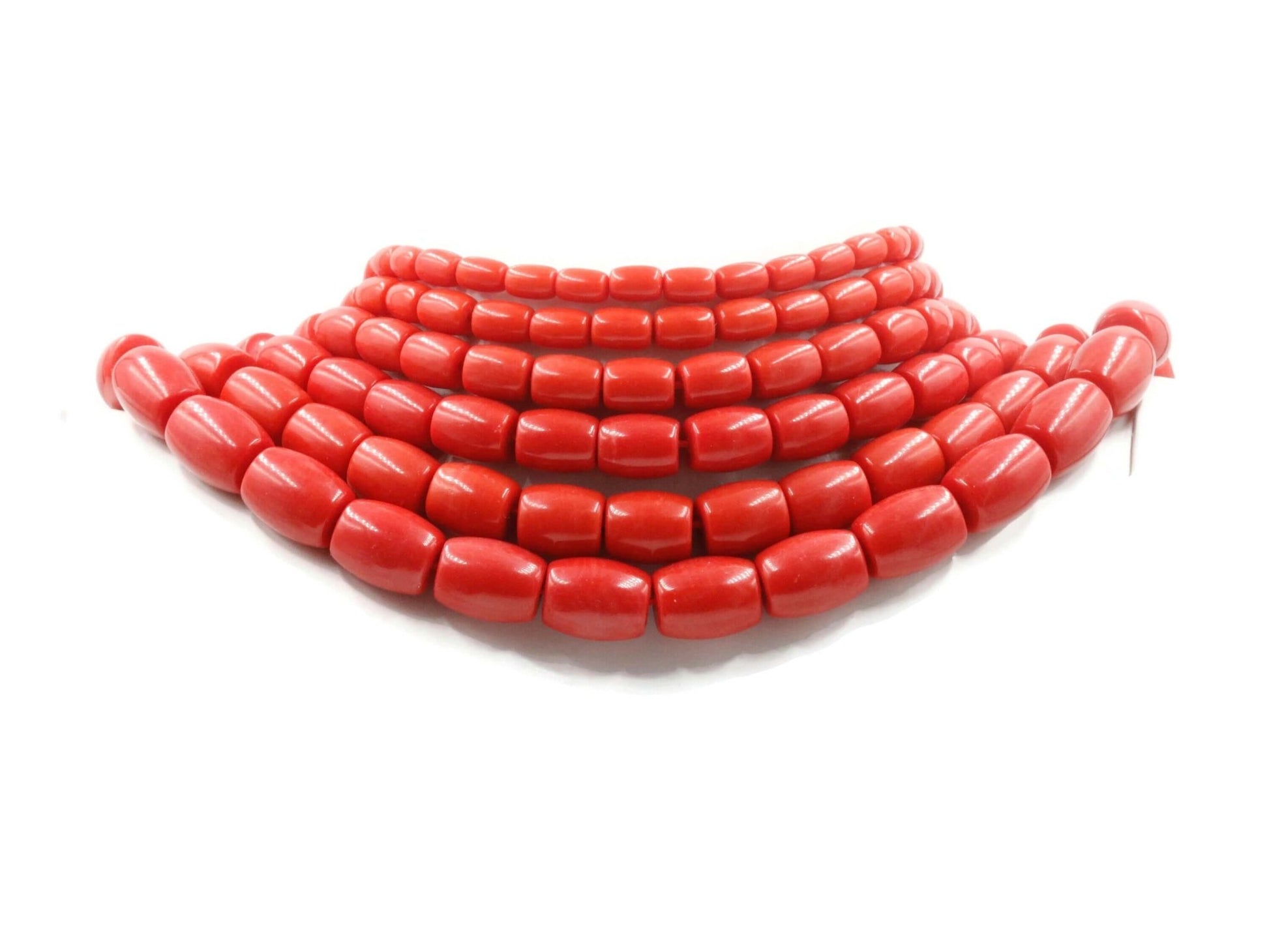 Natural coral beads strand displayed in vibrant red hues, perfect for unique jewelry design.