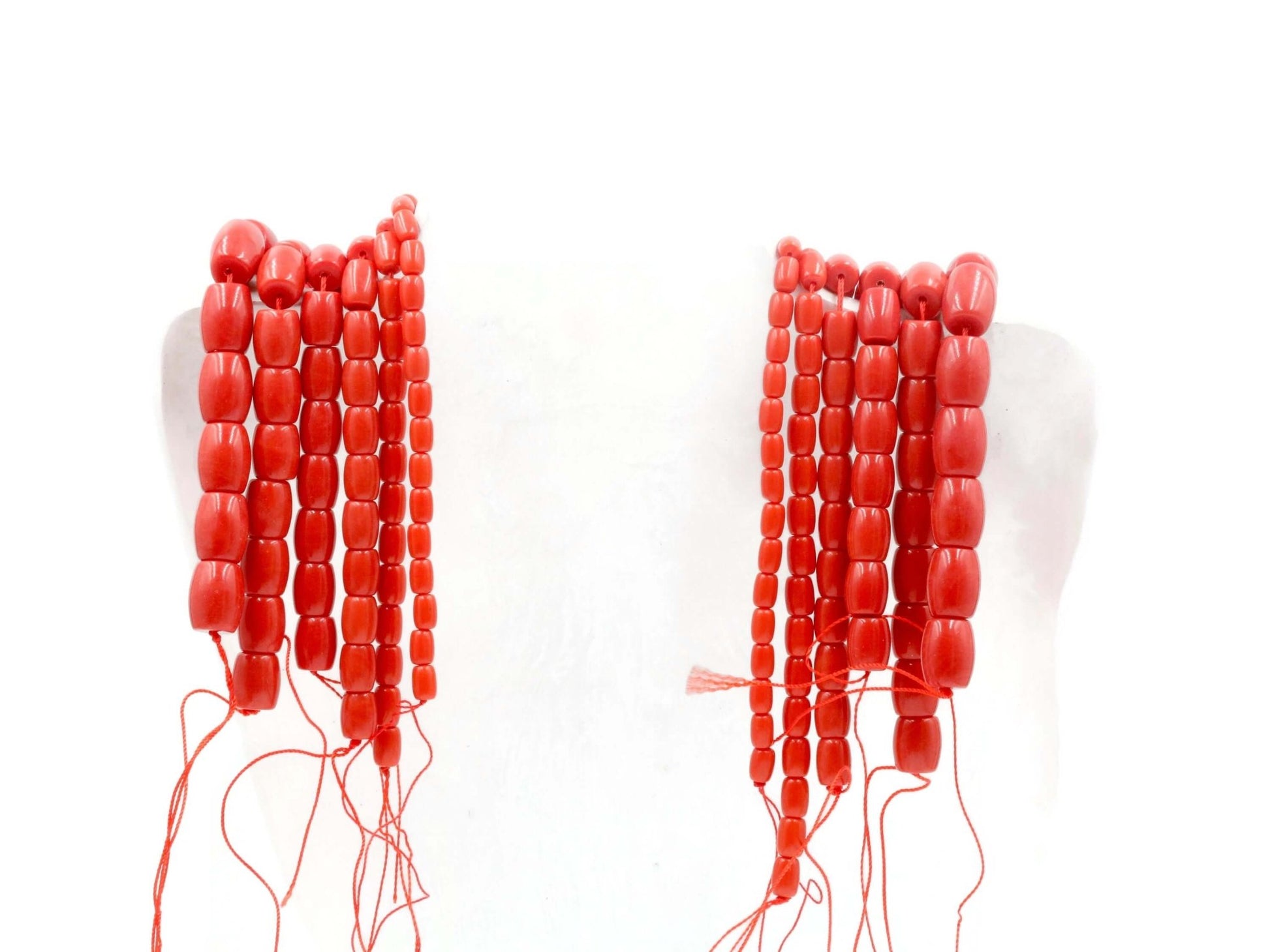 Natural coral beads strand displayed on a mannequin, showcasing their vibrant red color and unique design.