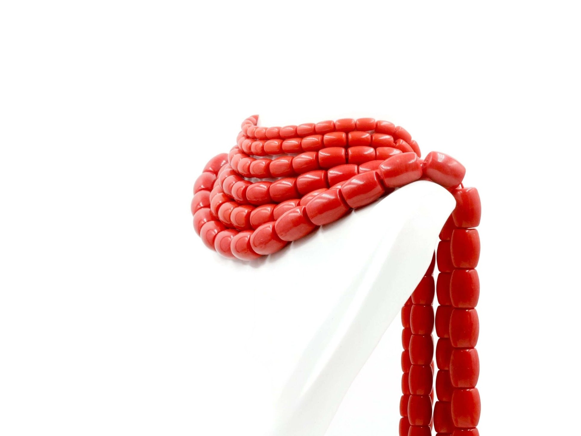 Natural coral beads strand displayed elegantly on a mannequin, showcasing a unique jewelry design.