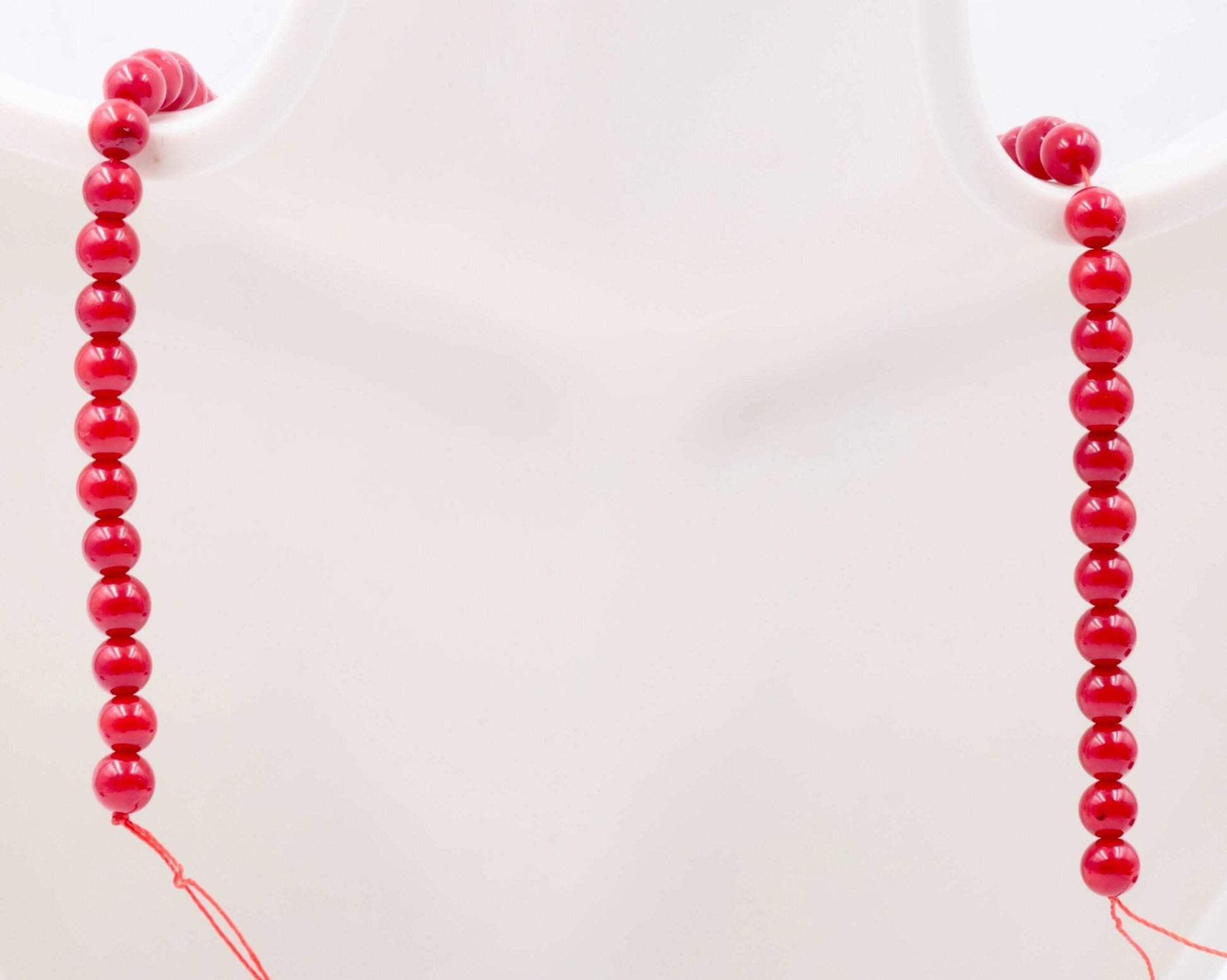 Natural Coral necklace displayed on a mannequin showcasing its vibrant red beads, symbolizing good luck and fortune.
