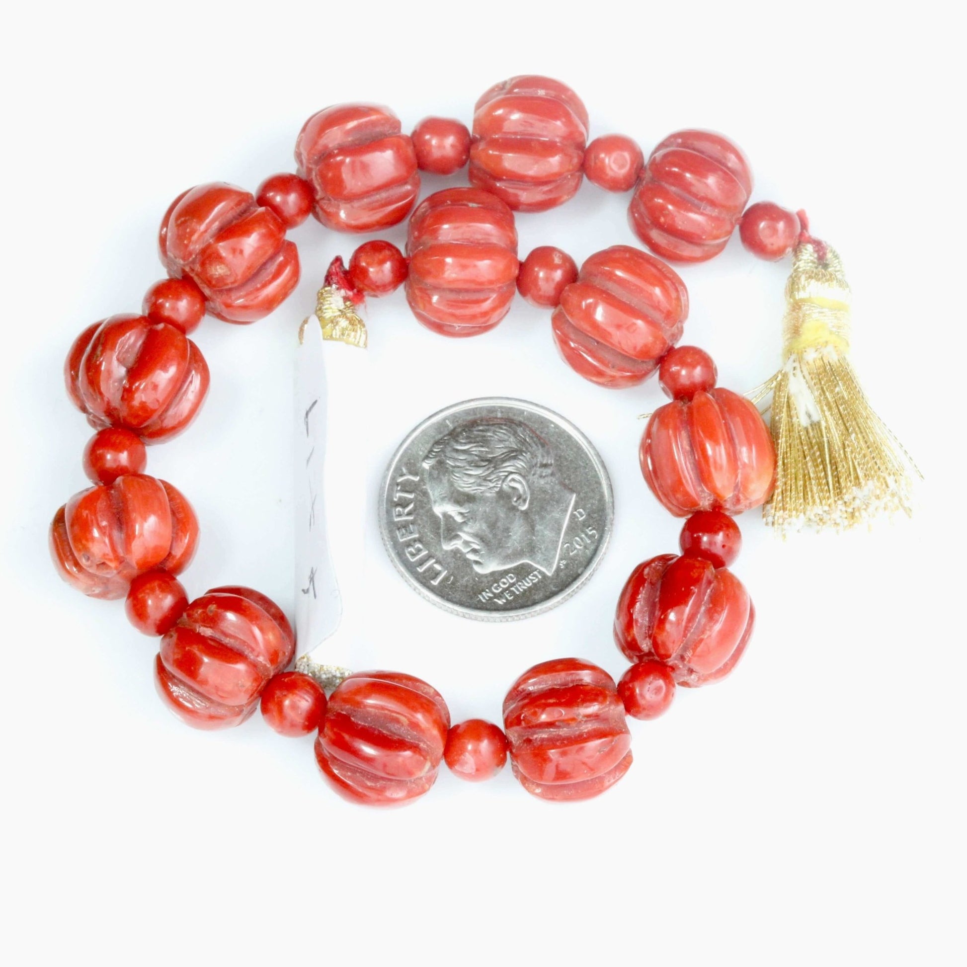 Coral Beads Strand featuring Italian Natural Red Coral with a measuring coin for scale.