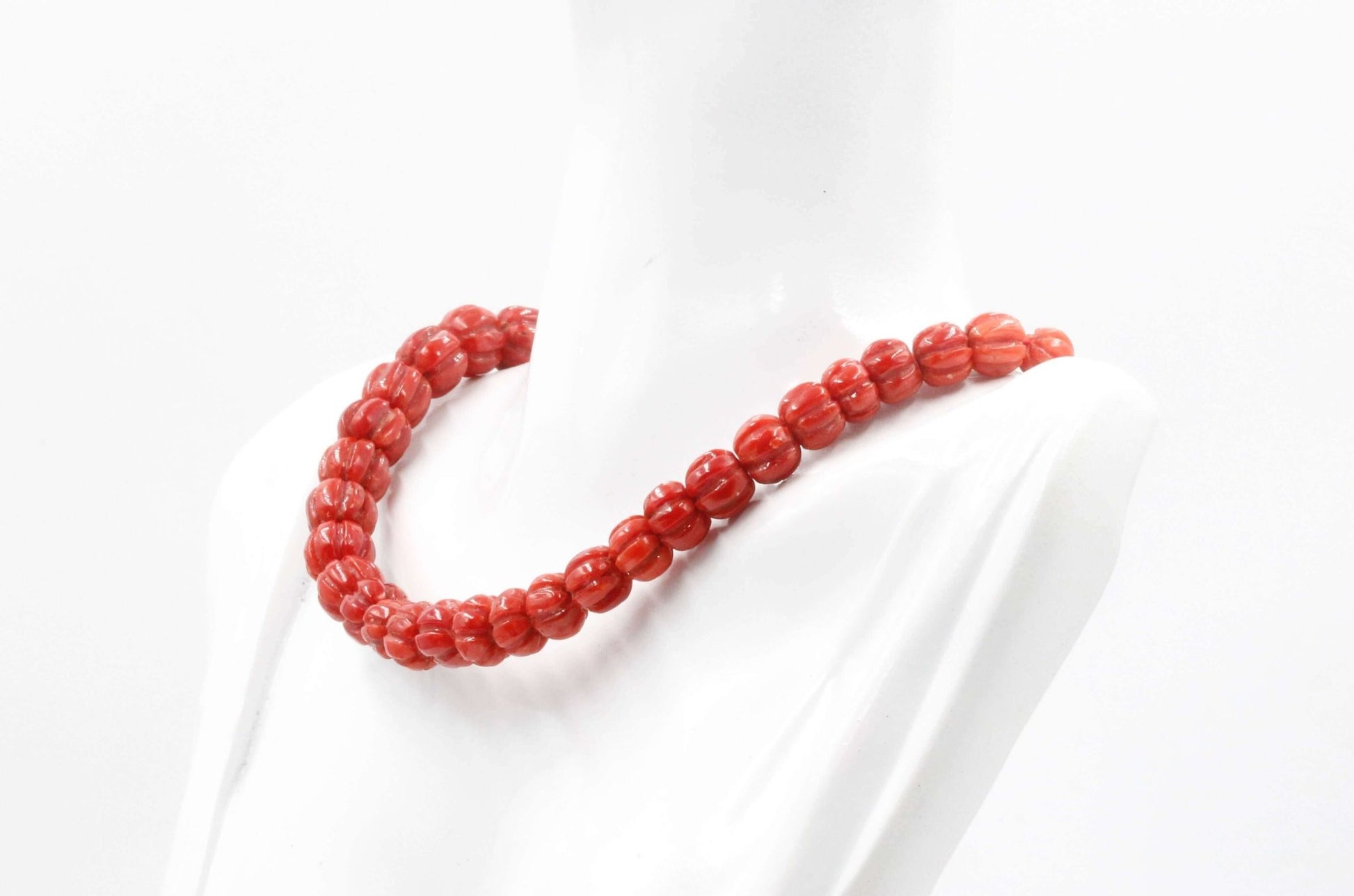 Natural Italian coral beads necklace displayed on a mannequin.