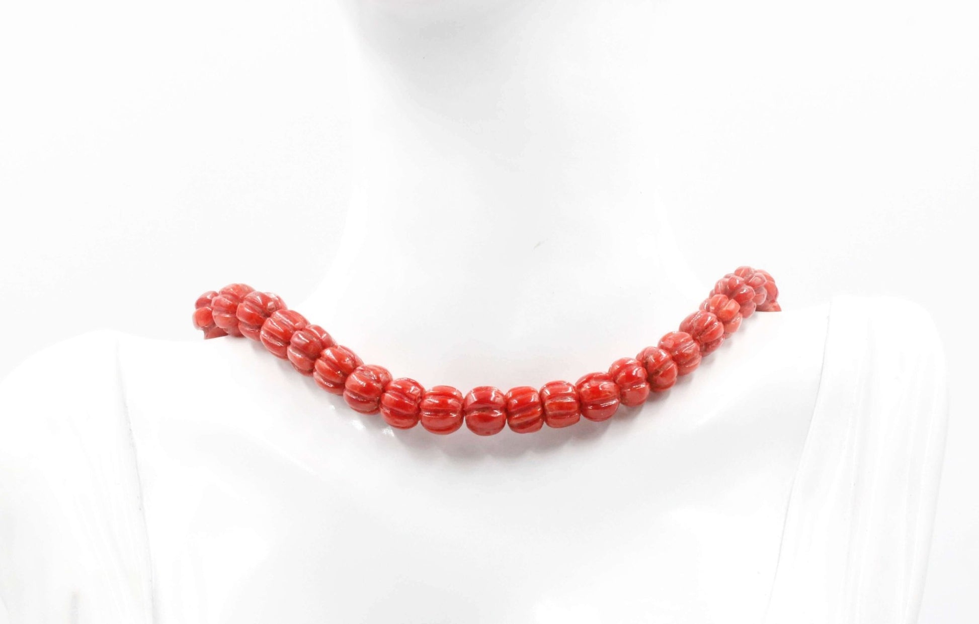 Natural Italian coral beads necklace showcasing vibrant red tones on a mannequin.