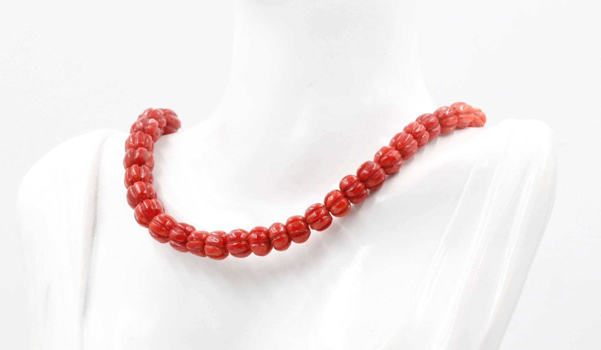 Natural Italian coral beads necklace displayed on a mannequin, showcasing vibrant red coral gemstones.