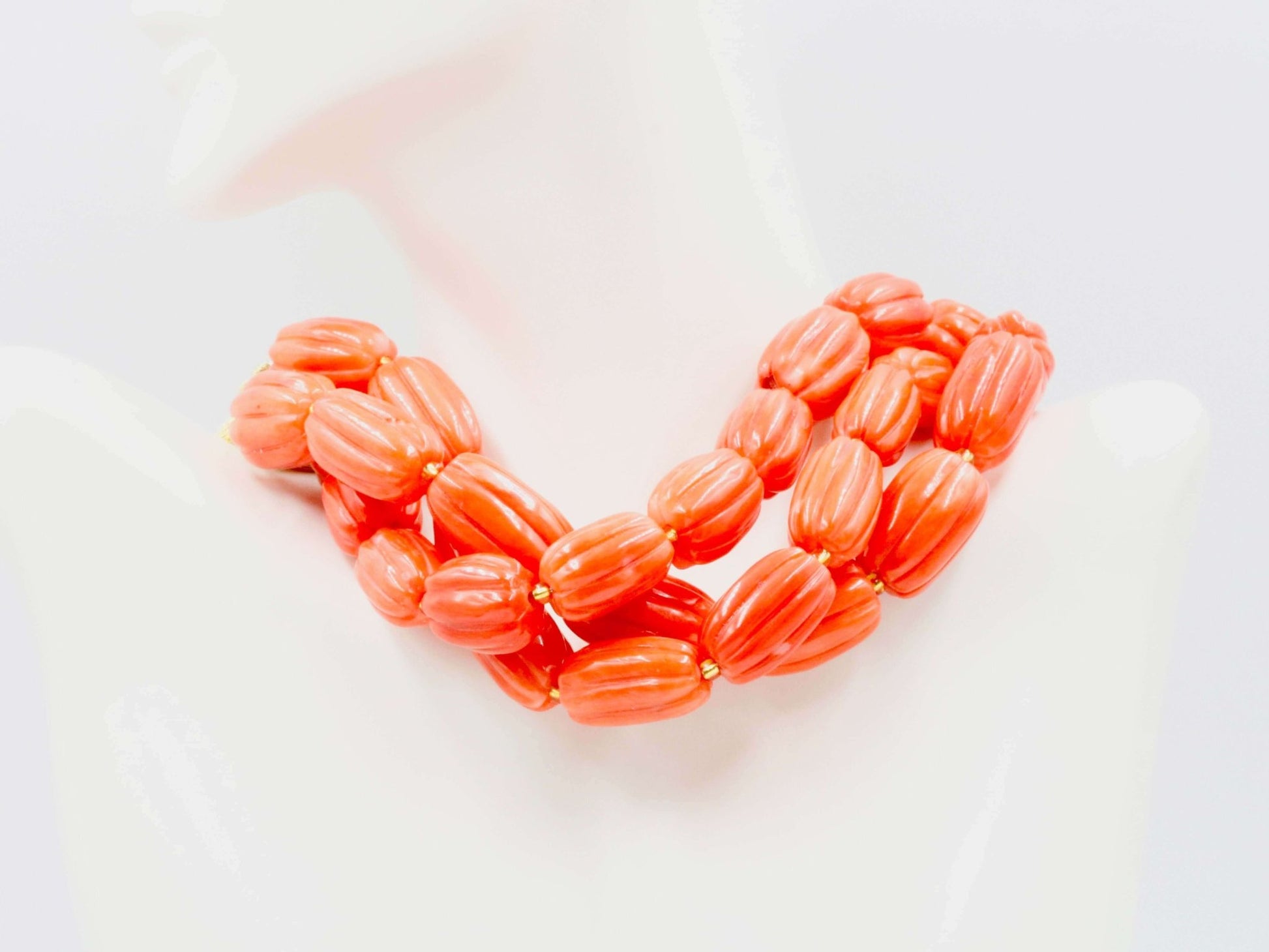 Natural orange coral beads strand showcased as a necklace with a pumpkin shape, vibrant and uplifting jewelry.