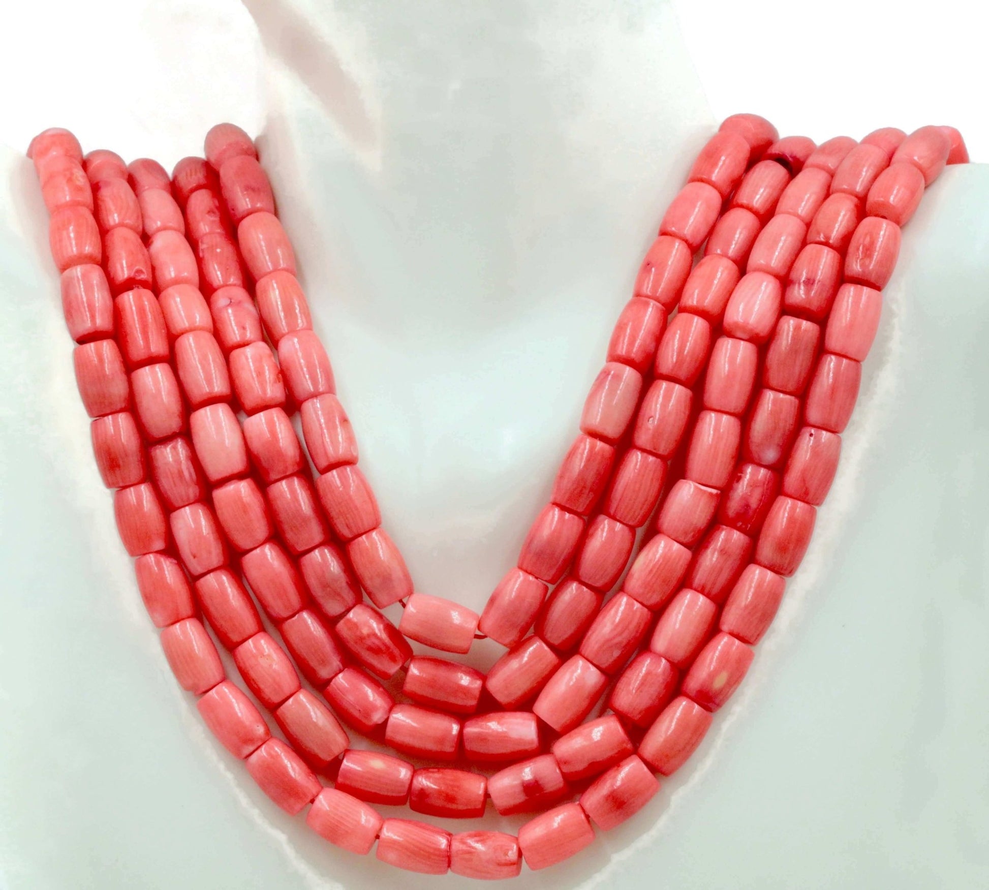Natural pink coral beads strand displayed elegantly with barrel cut beads in a semi-translucent pink hue.