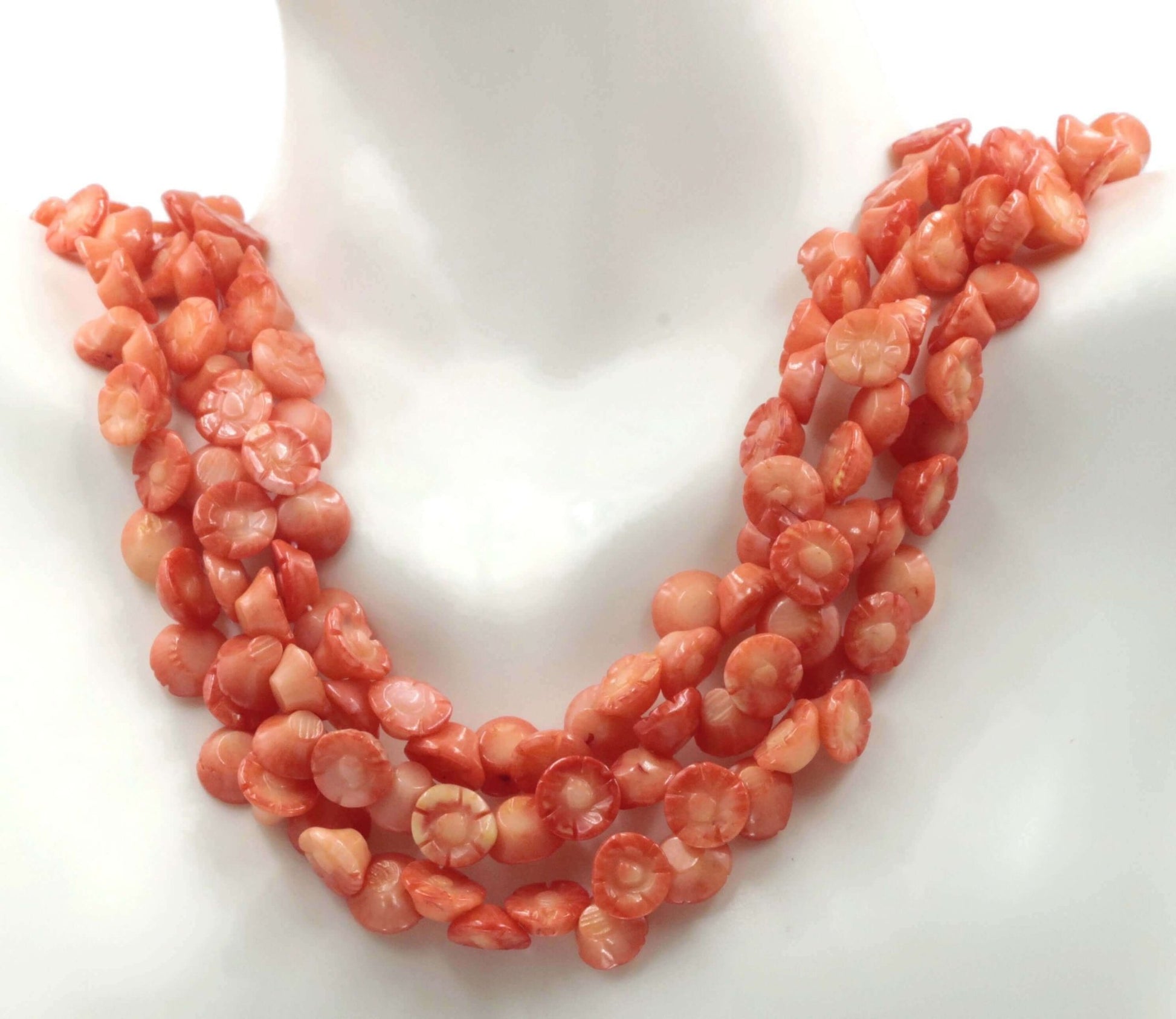 Orange Coral Flower Beads strand displayed on a mannequin showcasing vibrant orange hues and floral shapes.