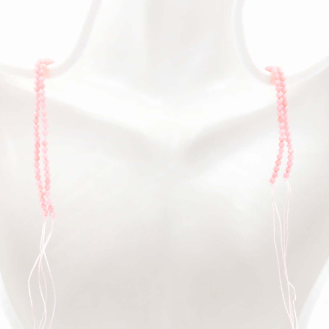 Pink coral beads strand displayed on a mannequin, showcasing unfinished strands ready for customization.
