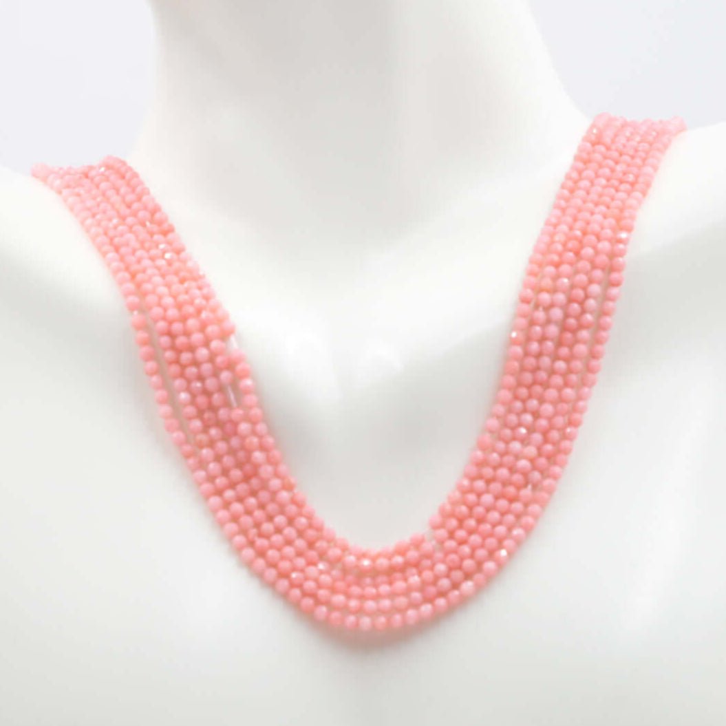 Pink coral beads strand showcasing round faceted beads ready for customization. Available in unfinished options.