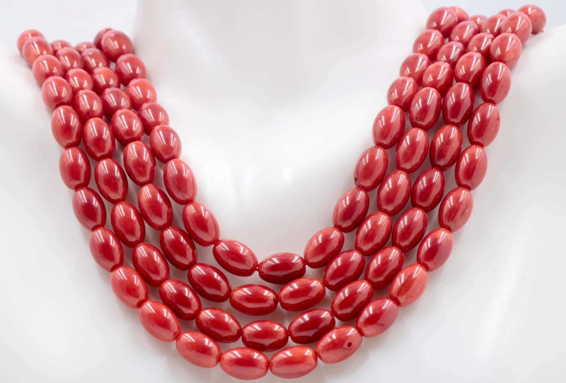 Red coral beads strand featuring multiple rows of vibrant red oval beads, showcasing natural gemstone beauty.